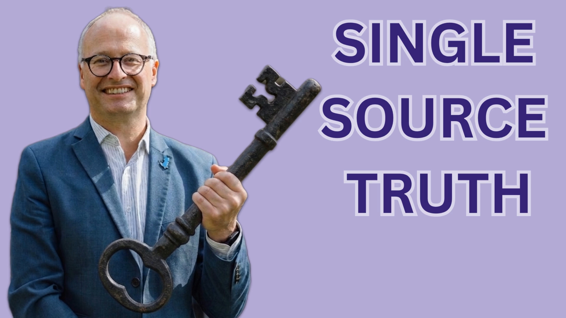 Man in a blue suit smiles while holding a large antique key, with the words 'Single Source Truth' on a purple background.